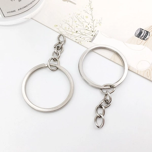Silver plated metal key rings with four-link chains and flat circular loops on white desk