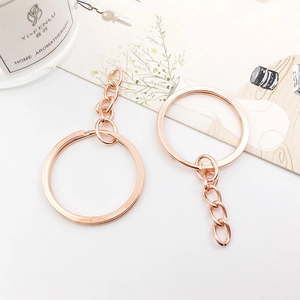 Rose gold metal keychain with split ring and short chain on a minimalist background