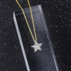 Elegant gold star pendant necklace with cubic zirconia on a minimalist star background