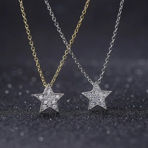 Detail of star-shaped necklaces in gold and silver with shimmering pavé zircon stones