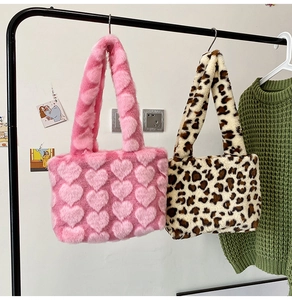 Detail of pink heart and leopard print plush tote bags hanging in home setting