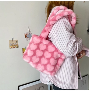 Shoulder shot of a soft pink faux fur tote bag with sweet heart patterns for autumn