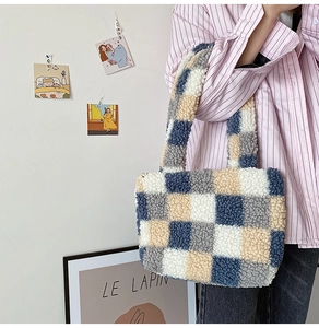 Detailed view of blue and beige plush checkerboard tote bag held by a model