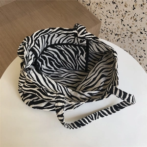 Detail view of large zebra pattern tote bag featuring a practical inner zipper pocket
