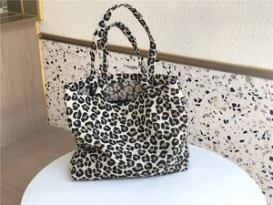 Detail of leopard print canvas tote bag texture with sturdy dual handle design
