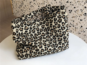 Detail shot of leopard print canvas tote bag with textured fabric and wide handles
