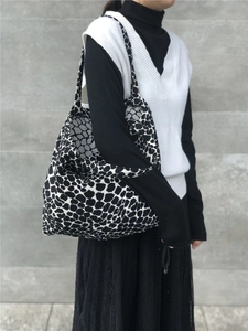 Close-up of oversized black and white animal print knitted tote bag with long shoulder straps