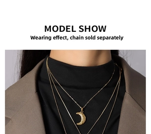 Detail of 18k gold plated moon pendant with hammered texture on a layered necklace