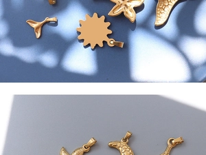 Detail of 18k gold plated moon and starfish pendants on a textured blue surface