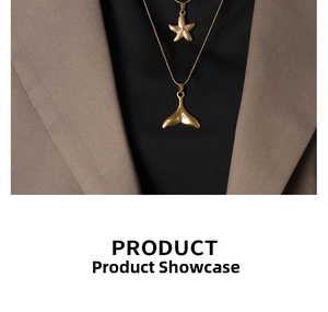 Detail of layered gold starfish and whale tail pendants on a beaded chain necklace