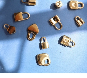 Close-up of assorted 18K gold plated vintage lock pendants on a blue textured surface