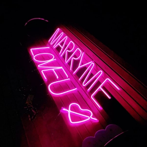 Pink neon sign MARRY ME and LOVEU with heart arrow for festive party wall decor