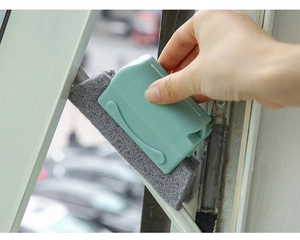 Close-up of hand using green crevice brush cleaning window track grime efficiently