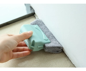 Handheld window track cleaning brush with microfiber pad scrubbing a sliding door groove