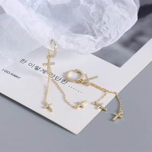 Detail of golden S925 silver cross tassel earrings with sparkling cubic zirconia inlay
