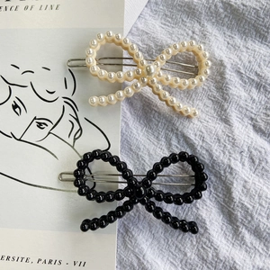 Set of minimalist black and cream beaded bow hair clips with elegant metal alligator clips