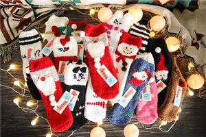 Detailed view of thick coral fleece Christmas socks with festive elk and santa patterns