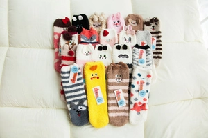 Detailed flat lay of colorful coral fleece socks with embroidered animal patterns