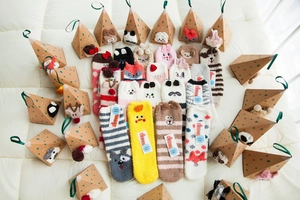 Detailed view of warm coral fleece Christmas socks in triangle gift packaging