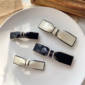 Detail of chic black and white bow-shaped resin hair clips in various sizes for women
