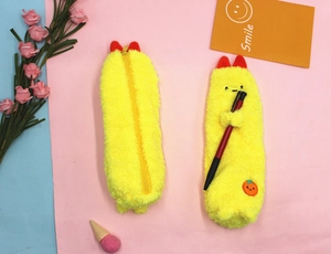 Detail of plush shrimp pencil case with orange embroidery on soft yellow fabric