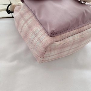 Detail view of purple fabric and pink checkered canvas stitching with black buckle