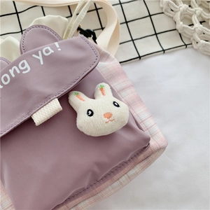 Close-up of cute purple canvas bucket bag with a 3D white plush rabbit detail