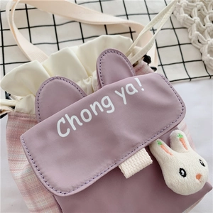 Close-up of cute purple canvas bucket bag featuring rabbit ears and rabbit doll pendant