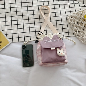 Close-up of purple and pink checkered drawstring bucket bag with cute rabbit pendant