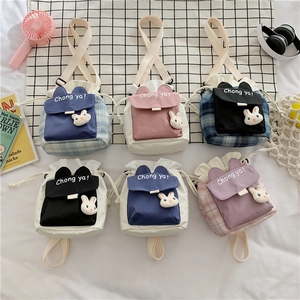 Flat lay of cute rabbit-themed canvas bucket bags in multiple colors and plaid patterns