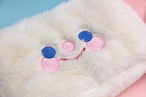 Vue détaillée de la peluche blanche douce et du joli visage souriant brodé sur le sac