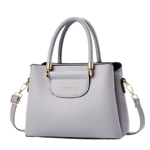 Grey litchi texture handbag with gold hardware and adjustable strap on white background