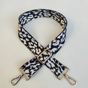 Detail of adjustable leopard print bag strap with polished gold-tone metal hooks