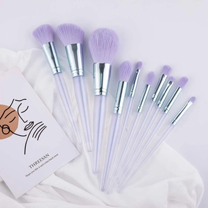 10-teiliges Make-up Pinselset mit lila Acryl-Kristallgriffen auf weißem Satin-Hintergrund
