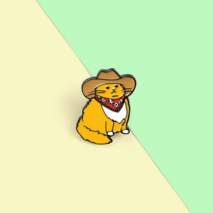 Detailed close-up of a cartoon orange cat enamel pin wearing a brown cowboy hat