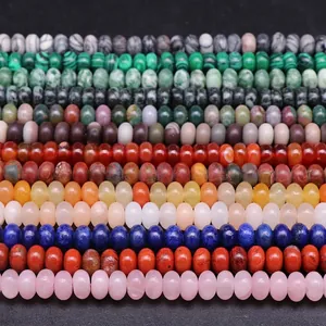 Polished colorful natural stone abacus beads arranged in rows on a black background