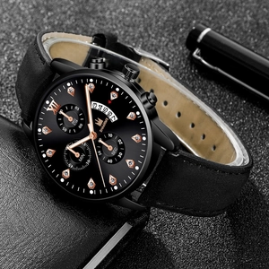 Close-up of business quartz watch with Roman numerals and leather strap on black desk