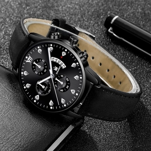 Detail of a black business watch with sub-dials, calendar display and leather strap