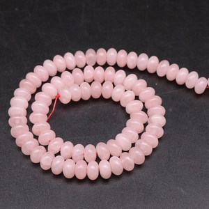 Macro detail of natural pink stone abacus beads on red string for jewelry making