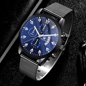 Détail macro d'une montre homme avec cadran bleu, chiffres romains et bracelet en maille