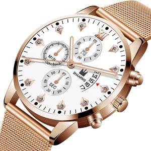 Détail d'une montre d'affaires or rose avec index diamants et bracelet en maille sur blanc