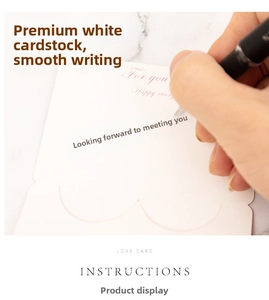 Close-up of hand writing on a white heart-shaped 3D card with For You text