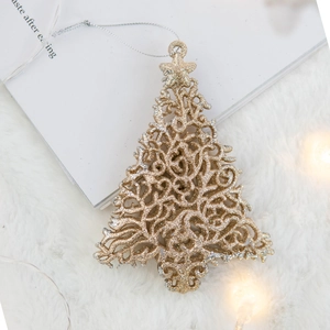 Golden glitter Christmas tree ornament with intricate cutout patterns on a plush background