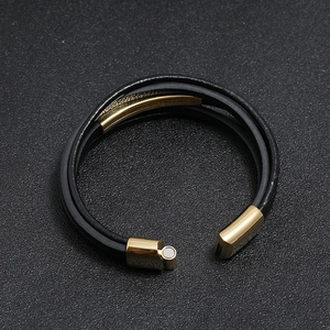 Detail view of multi-layer braided leather bracelet with black and gold magnetic clasp