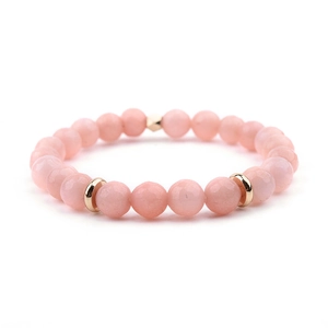 Detail of pink crystal beaded bracelet with polished round stones and golden metal accents