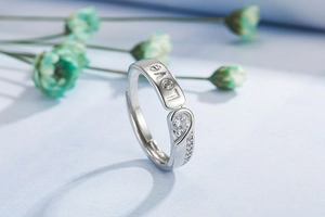 Macro shot of silver couple ring with I LOVE YOU engraving and sparkling zircon stone