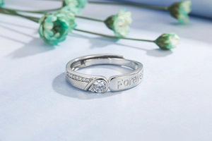 Macro shot of silver ring with Forever engraving and brilliant zircon stones