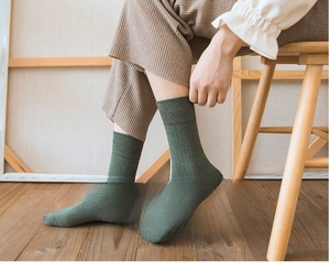 Close-up of ribbed cotton medium tube socks in dark green showing texture and fit