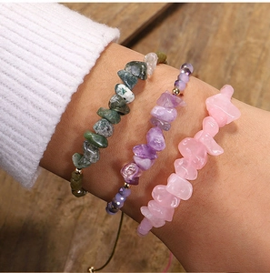Detalle de pulseras artesanales con piedras naturales irregulares en verde, púrpura y rosa