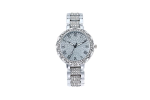 Gros plan d'une montre argentée avec cristaux, chiffres romains et cadran brillant diamants